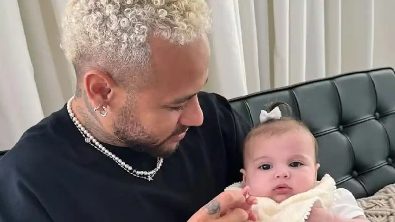 Neymar poses with his daughter Helena on his lap, in a special recording during a visit to Brazil - photo: reproduction